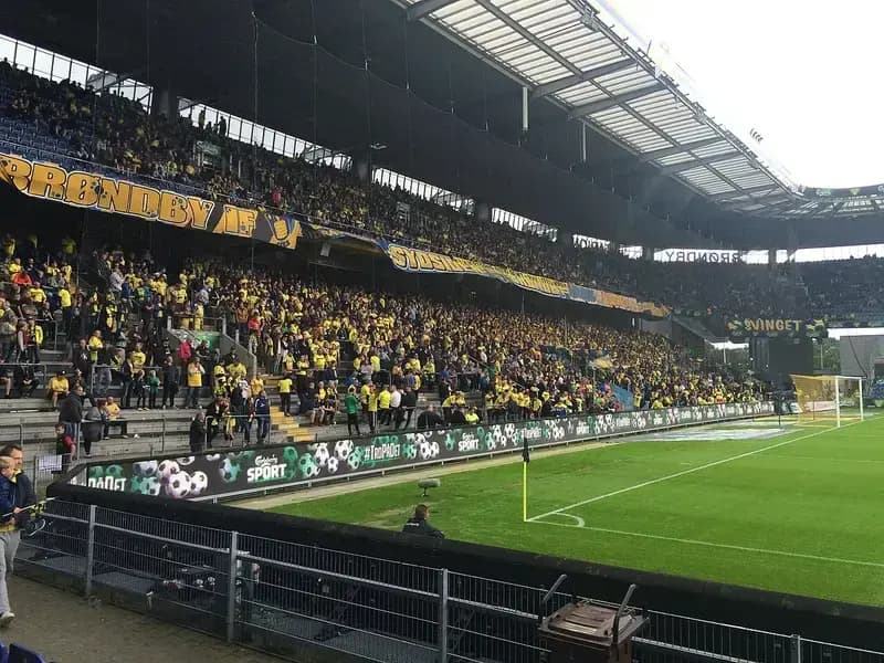 Brøndby IF football fans in yellow shirts in stadium stands