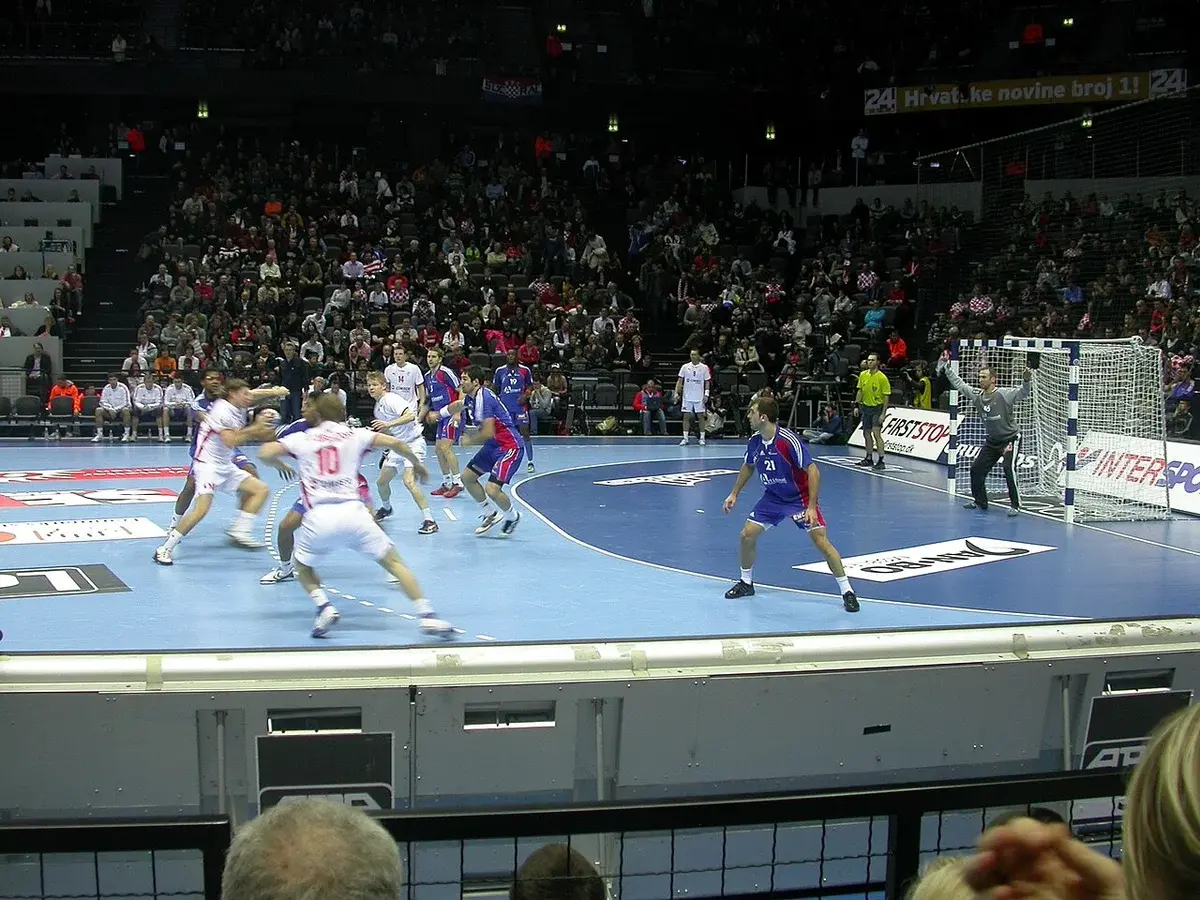 Handball players in action during an indoor match.