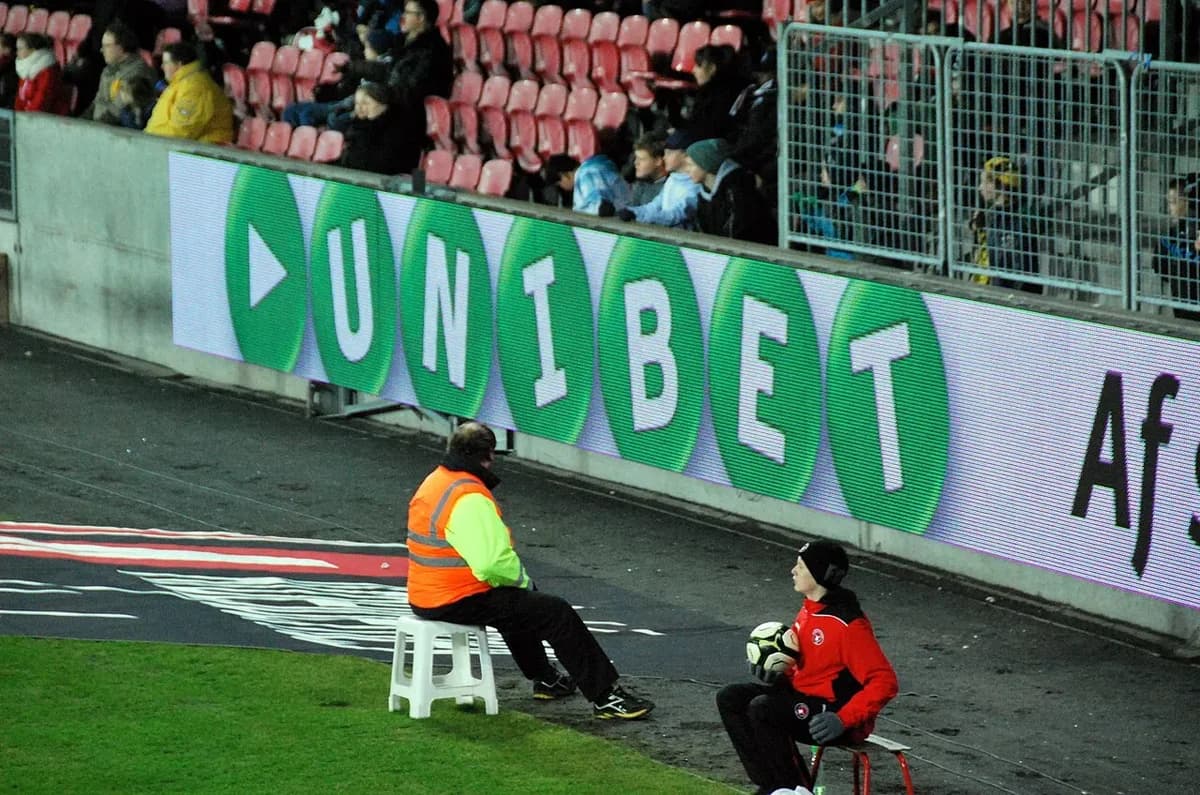 steward and ball boy sitting near soccer pitch