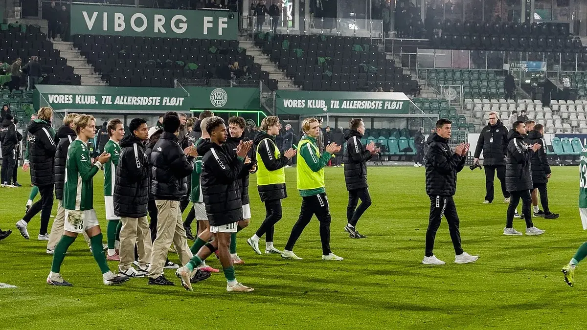 Viborg FF players standing together and applauding on the pitch after a match.