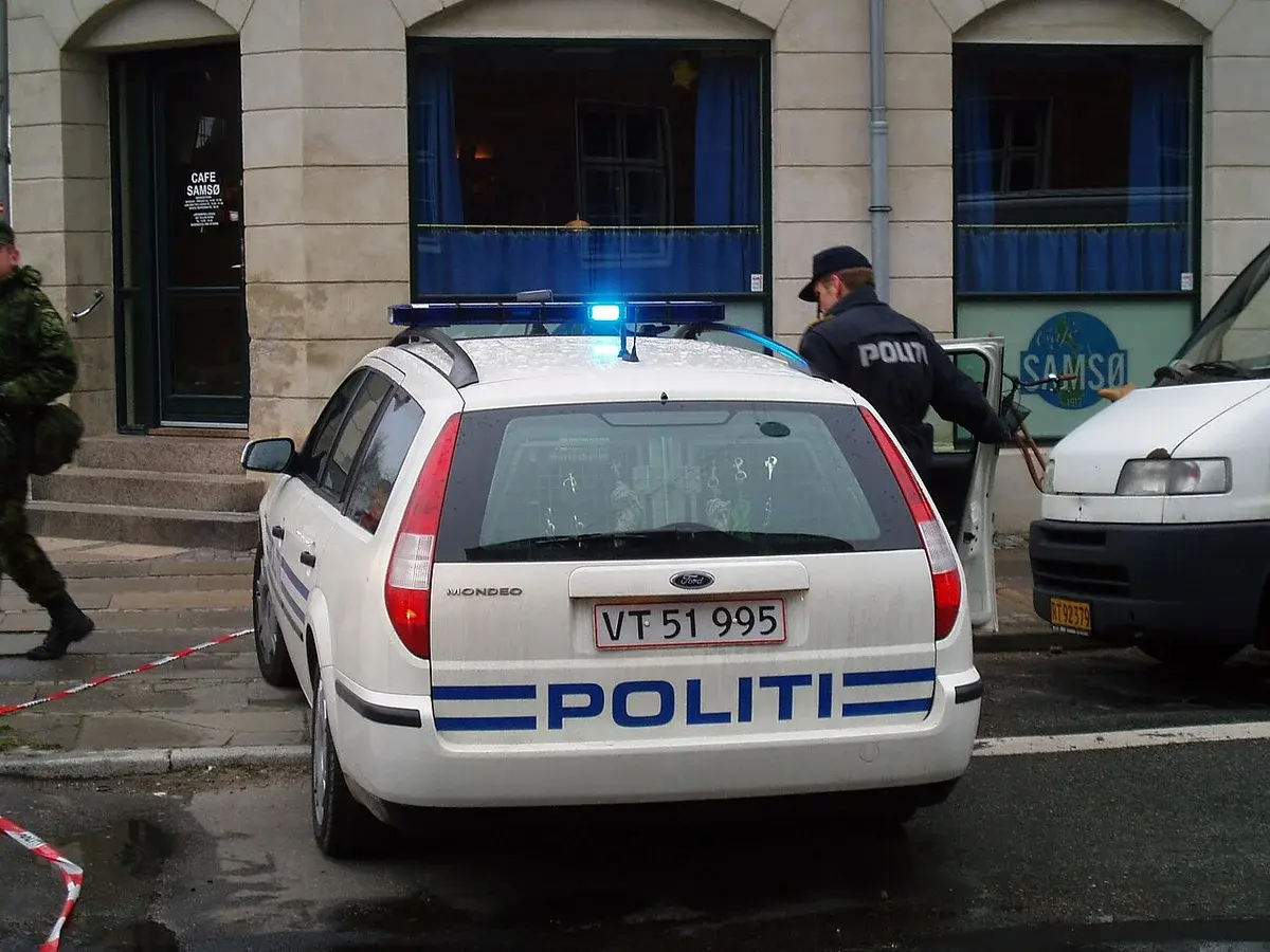 Rear view of a Copenhagen Police Ford Mondeo station wagon with flashing lights.