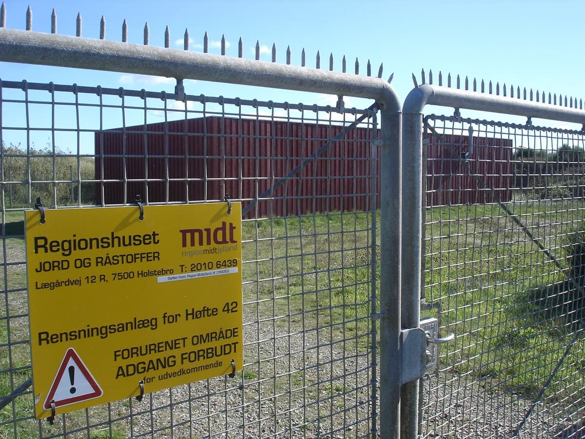A fenced remediation plant with a warning sign at Høfde 42.
